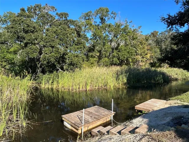 a view of a lake with couches and wooden fence