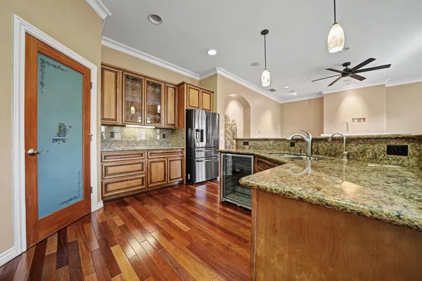 a kitchen with stainless steel appliances granite countertop a sink a stove and a refrigerator