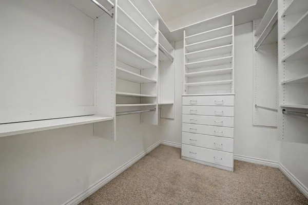 a view of walk in closet with empty racks