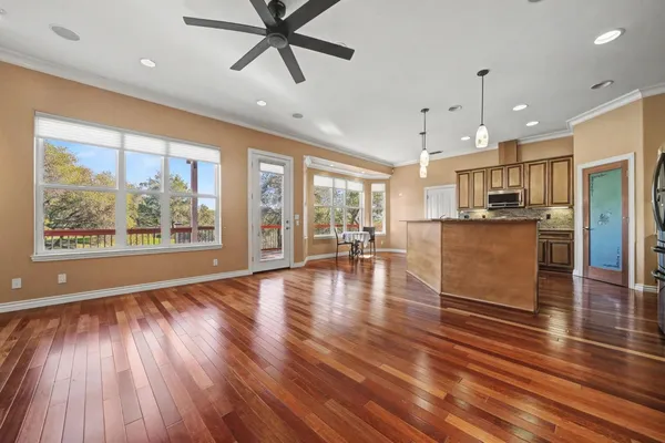 a room with stainless steel appliances wooden floors and kitchen view