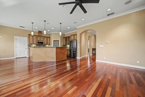 a view of a big room with wooden floor and windows