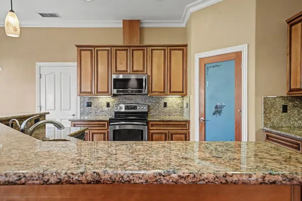 a kitchen with stainless steel appliances granite countertop a stove a sink and a refrigerator
