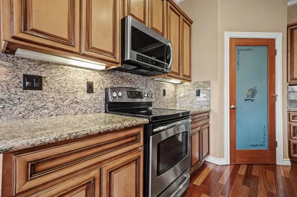 a kitchen with stainless steel appliances granite countertop a stove microwave and cabinets