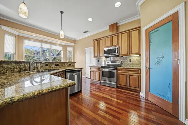 a kitchen with stainless steel appliances granite countertop a sink refrigerator and cabinets
