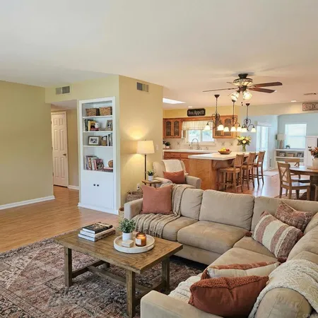 a living room with furniture and view of kitchen