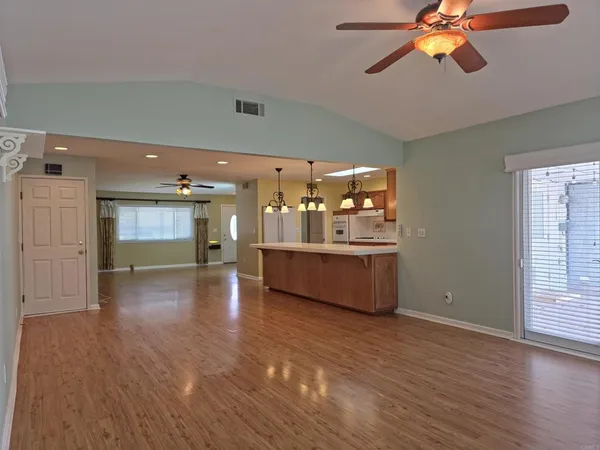 a living room with kitchen view and wooden floor