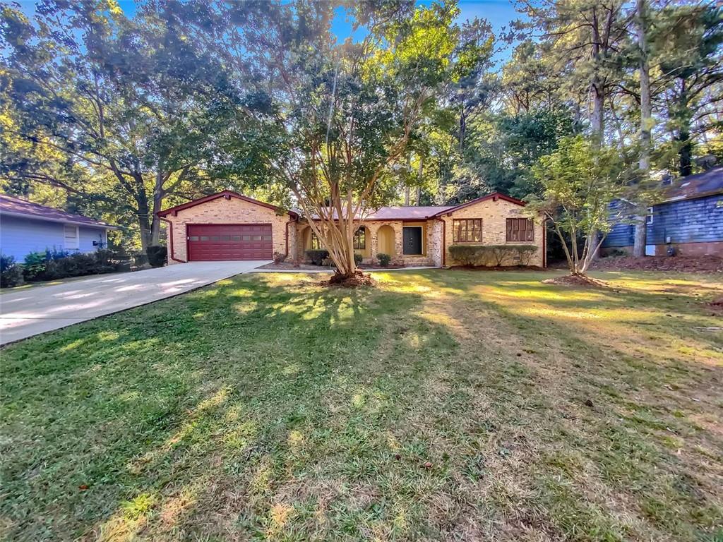 a view of a house with a big yard and large trees