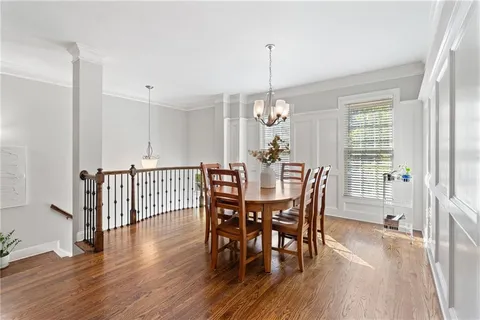 a view of a dining room and livingroom with furniture wooden floor a chandelier