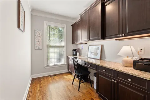 a kitchen with granite countertop wooden cabinets and wooden floor