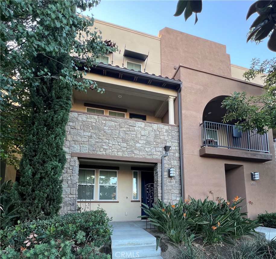 a front view of a house with plants