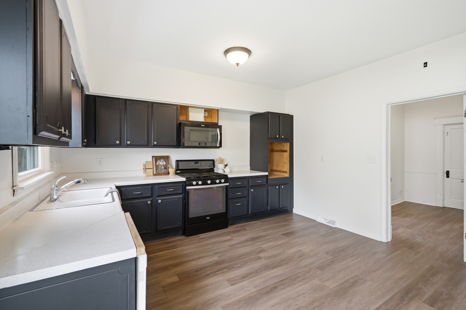 1847 10th Street Moline, IL 61265 - Photo 17 of 39 a kitchen with a sink wooden floor and black appliances