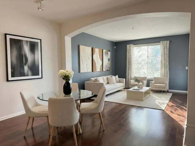 a view of a dining room with furniture a potted plant and wooden floor