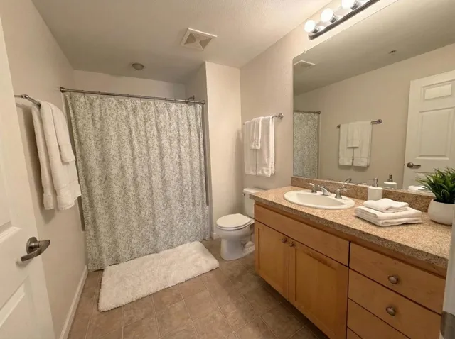 a bathroom with a granite countertop sink toilet and shower