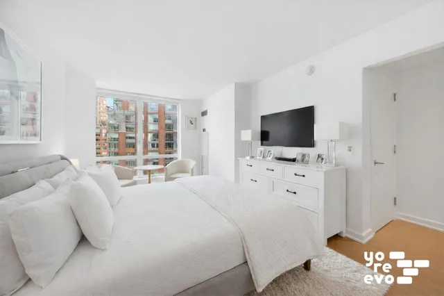 a bedroom with furniture and a large window