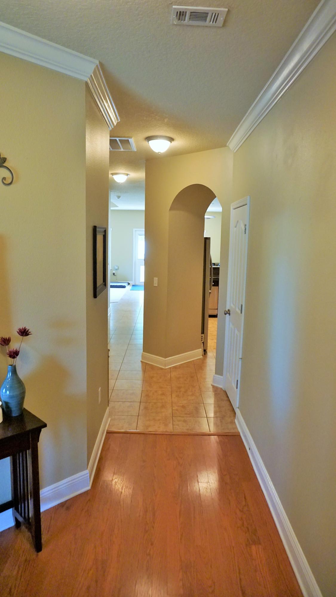632 Red Fern Road Crestview, FL 32536 - Photo 3 of 36 a view of a hallway with wooden floor and furniture