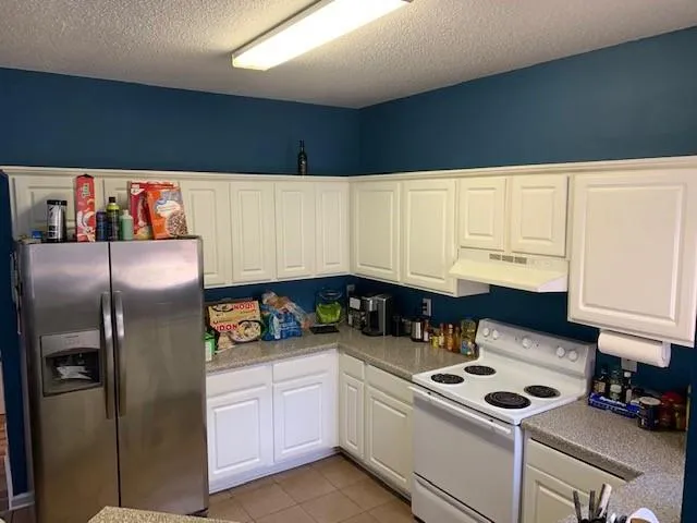 a kitchen with stainless steel appliances a stove a refrigerator and cabinets