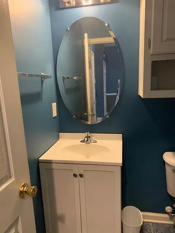 a bathroom with a toilet sink and mirror