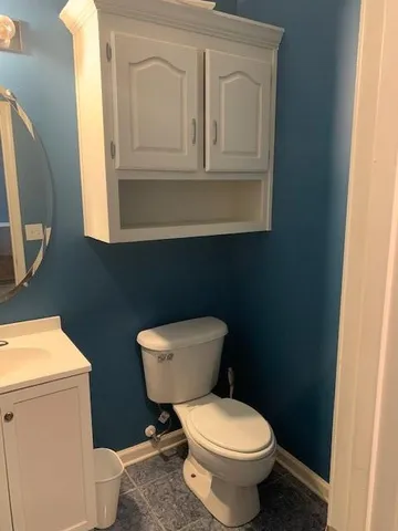 a white toilet sitting next to a bathroom sink