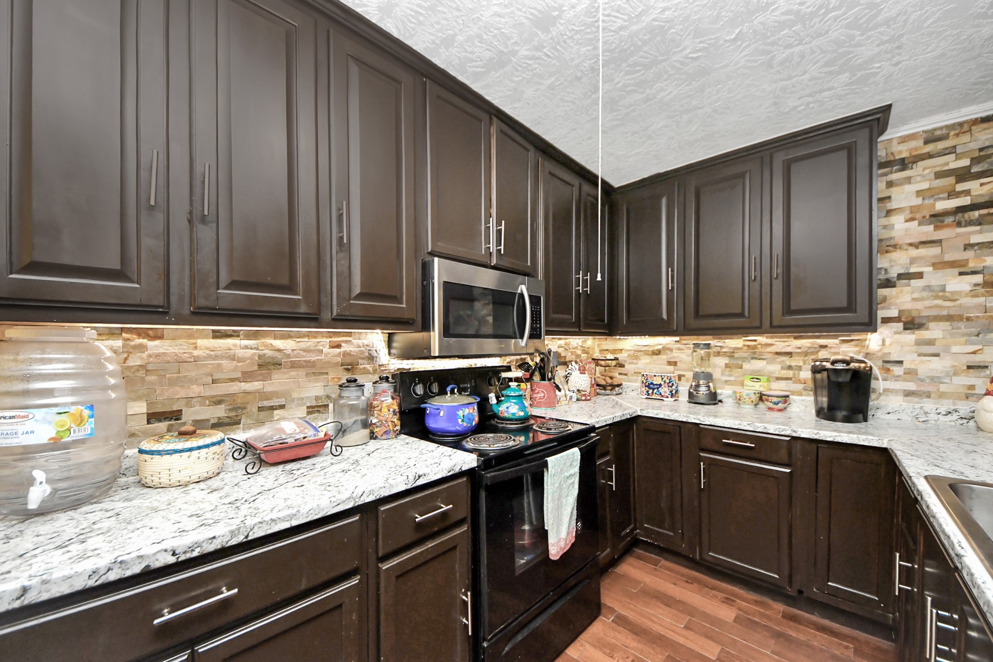 1040 County Road 5007 Cleveland, TX 77327 - Photo 11 of 47 a kitchen with stainless steel appliances granite countertop a sink stove and cabinets