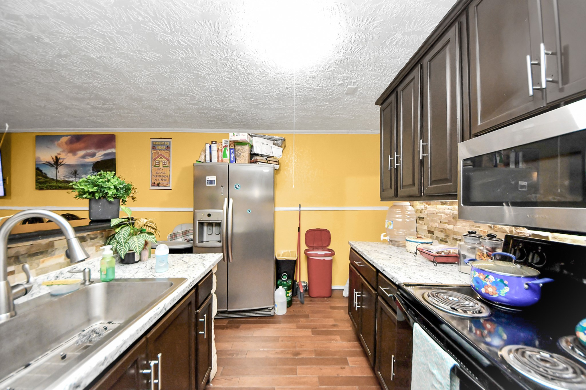 1040 County Road 5007 Cleveland, TX 77327 - Photo 13 of 47 a kitchen with stainless steel appliances granite countertop a sink stove and refrigerator