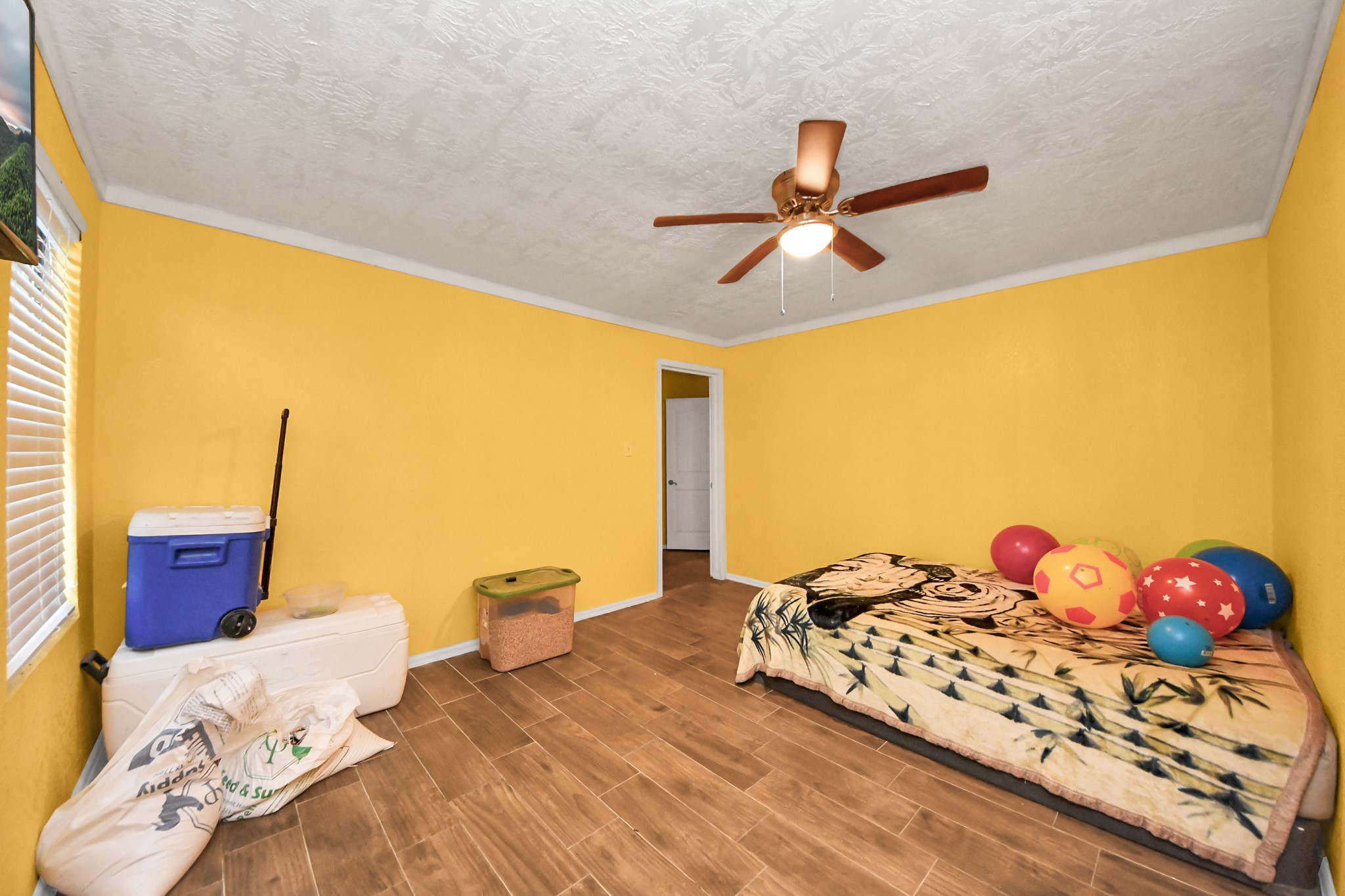 1040 County Road 5007 Cleveland, TX 77327 - Photo 15 of 47 a bedroom with a bed and dresser with wooden floor