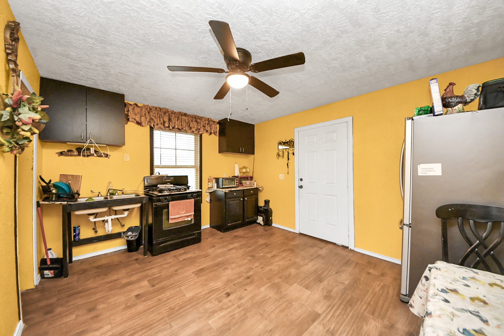 1040 County Road 5007 Cleveland, TX 77327 - Photo 19 of 47 a kitchen with stainless steel appliances wooden floor and a refrigerator