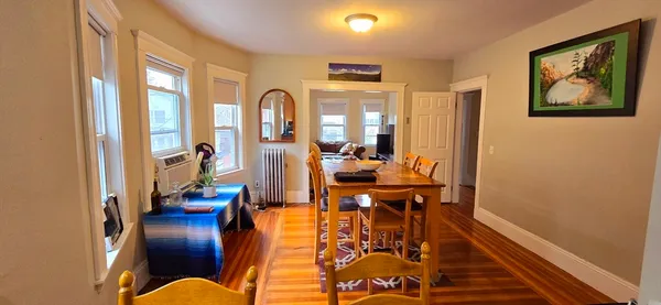 a view of a dining room with furniture a chandelier and wooden floor