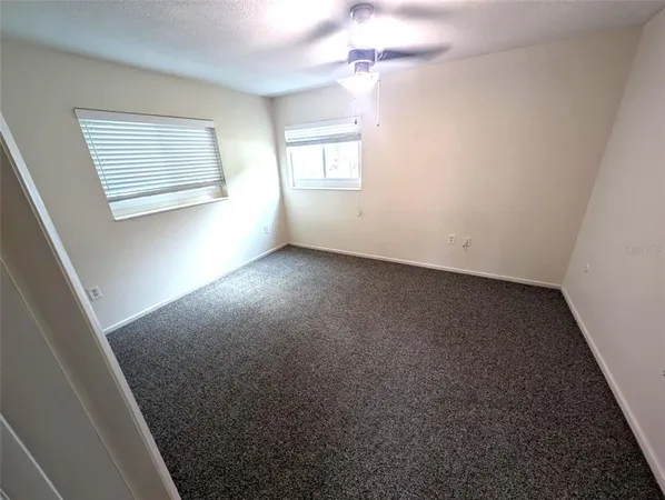 an empty room with windows and closet