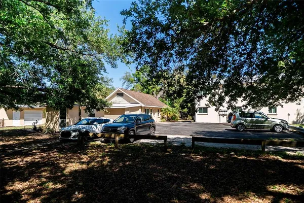 a view of house with backyard and trees