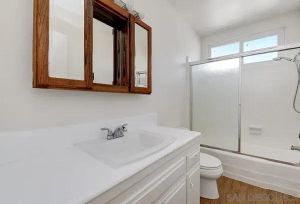 a bathroom with a sink a toilet and shower