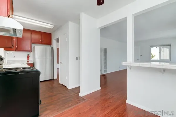 a kitchen with a refrigerator and a stove top oven