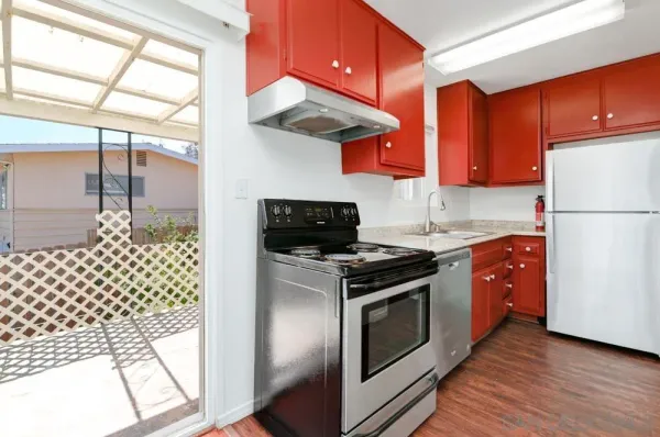 a kitchen with a stove a refrigerator and cabinets