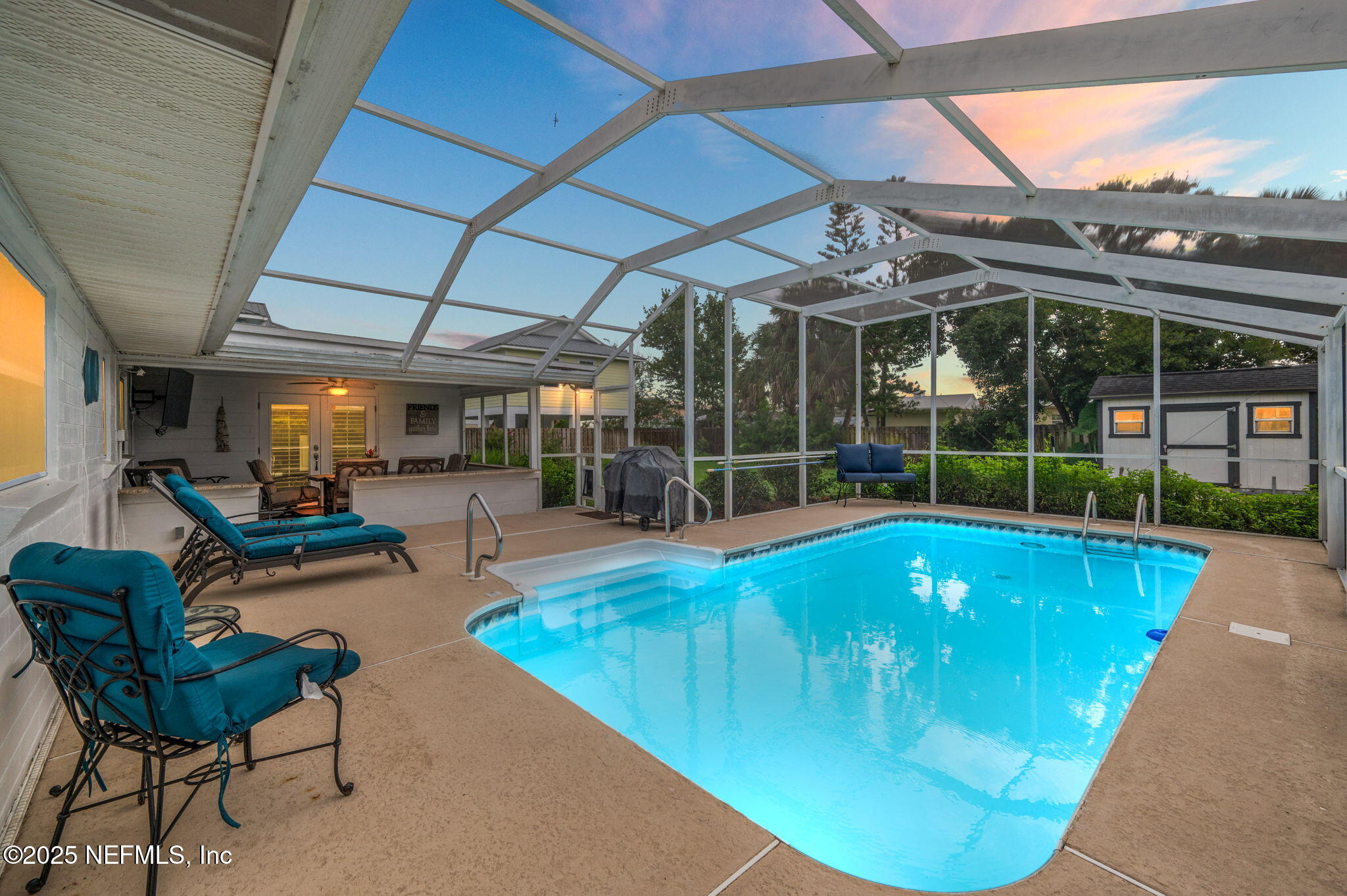 a view of a backyard with swimming pool and sitting area