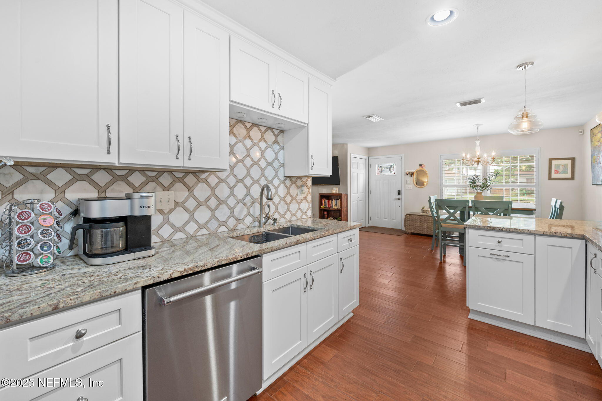 5454 2nd Street St. Augustine, FL 32080 - Photo 11 of 58 a kitchen with stainless steel appliances granite countertop a sink stove and white cabinets with wooden floor