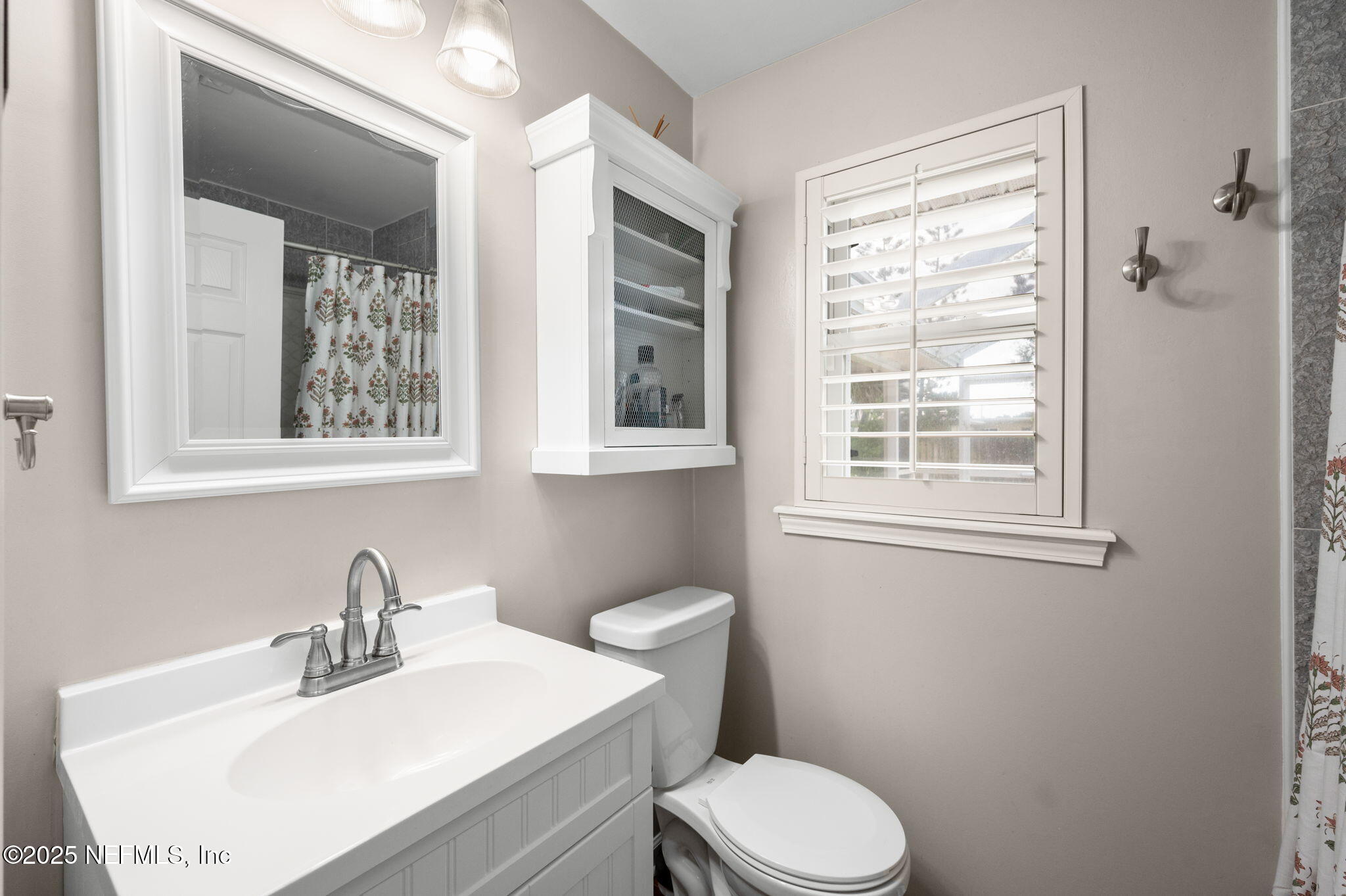 5454 2nd Street St. Augustine, FL 32080 - Photo 30 of 58 a bathroom with a sink a toilet and a window