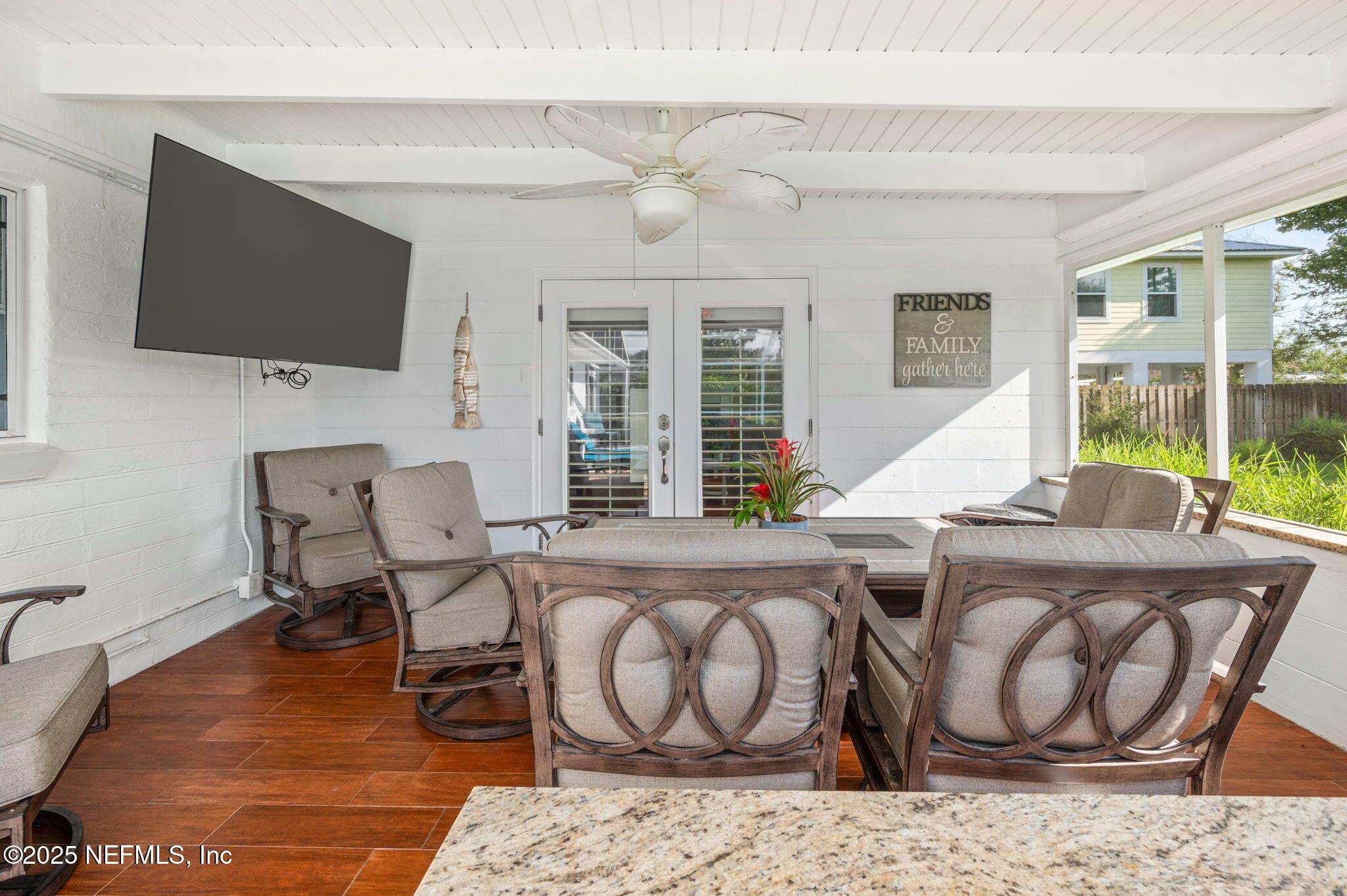 5454 2nd Street St. Augustine, FL 32080 - Photo 36 of 58 a living room with furniture a flat screen tv and a floor to ceiling window
