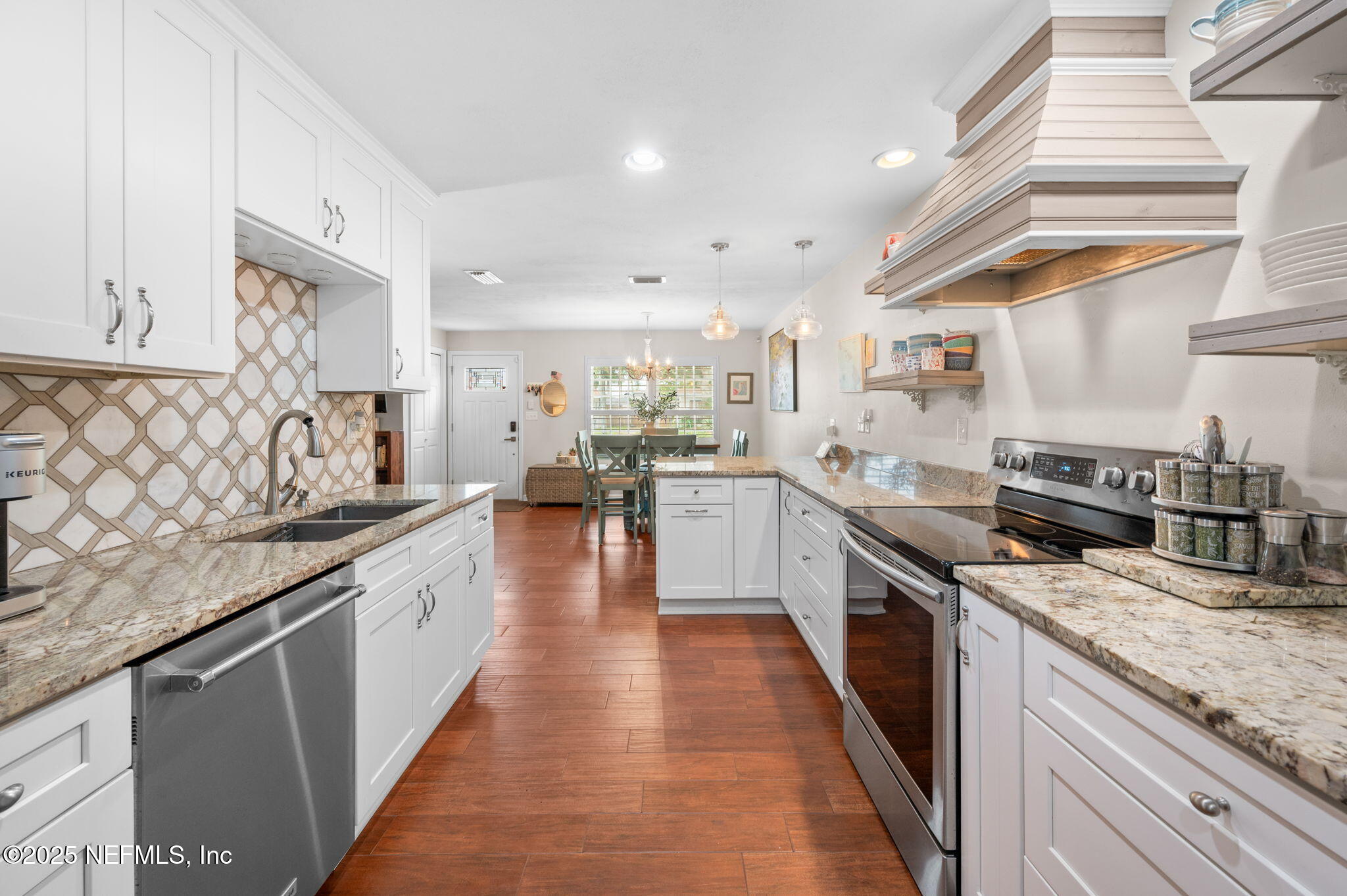 5454 2nd Street St. Augustine, FL 32080 - Photo 10 of 58 a large kitchen with stainless steel appliances granite countertop a lot of counter space and wooden floors