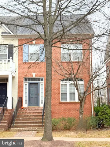 a front view of a house with a tree
