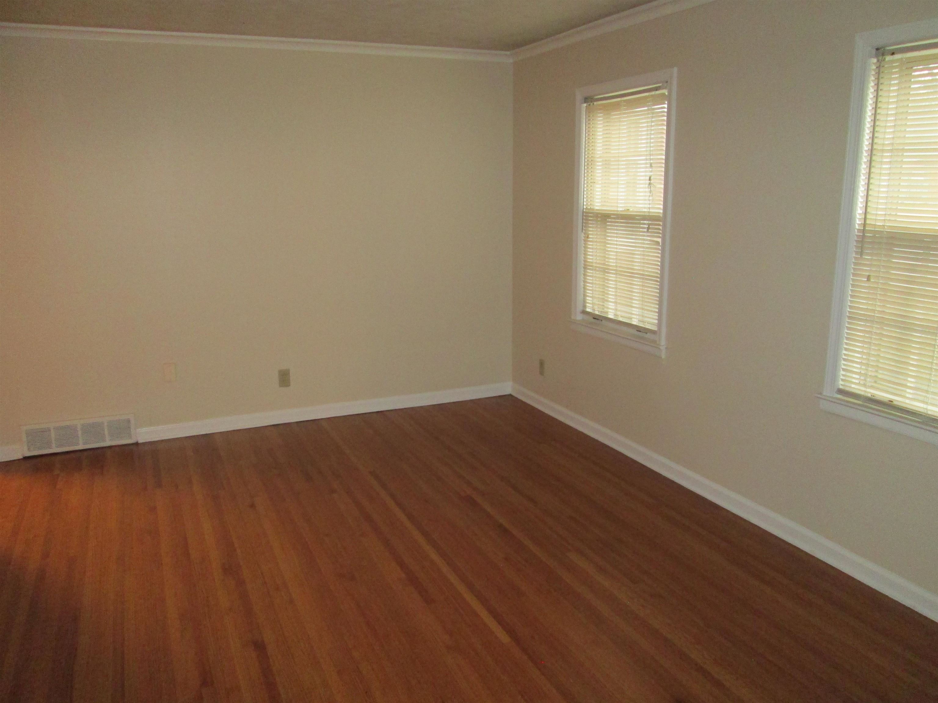 4616 Dunn Road Memphis, TN 38117 - Photo 4 of 20 an empty room with wooden floor and windows