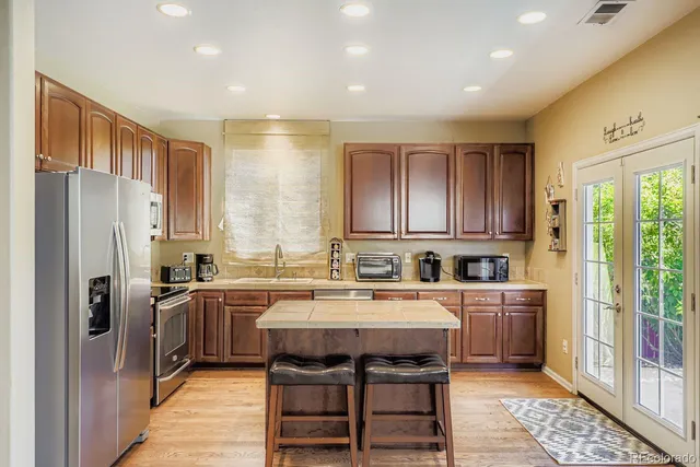 a kitchen that has a sink a stove and chairs