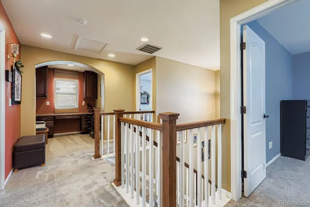 a view of a hallway with a livingroom with furniture and staircase