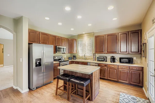a kitchen with a sink a counter top space stainless steel appliances and cabinets