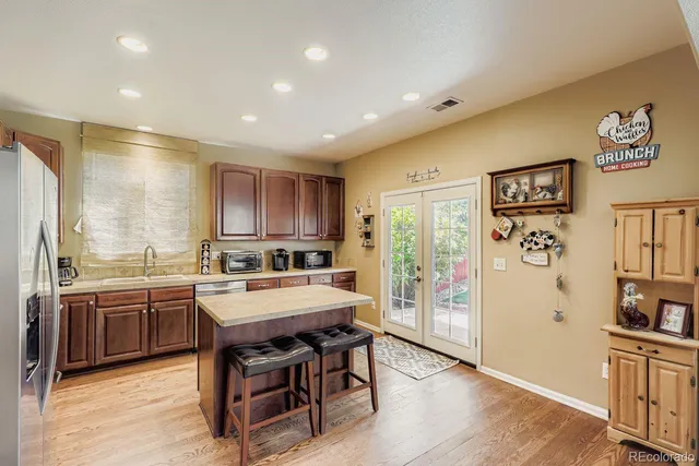 a kitchen with stainless steel appliances granite countertop a refrigerator and a stove top oven