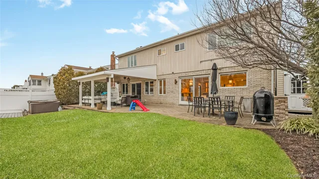 a view of a house with patio and a yard