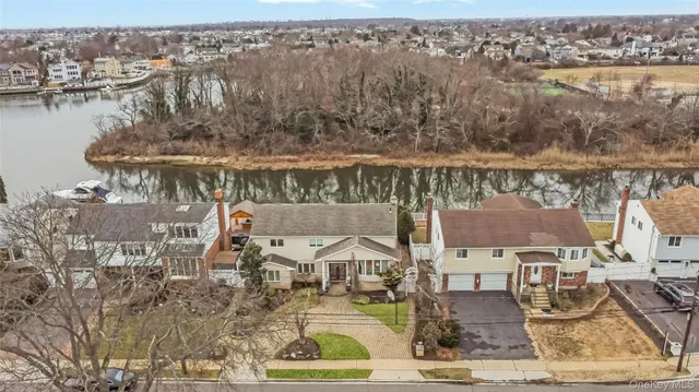 an aerial view of residential houses with outdoor space and lake view