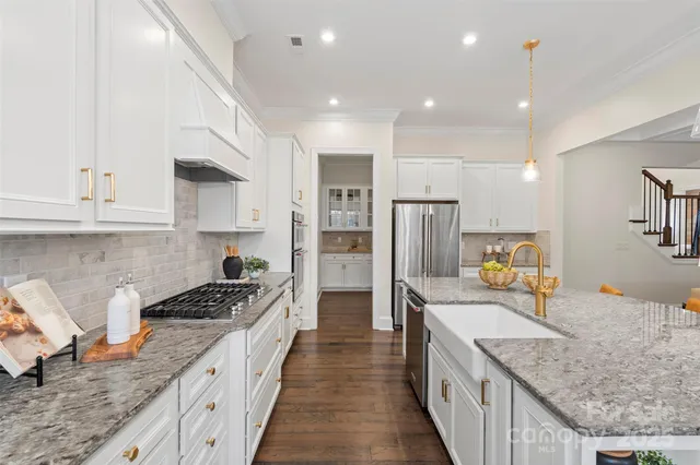 a large kitchen with stainless steel appliances granite countertop plenty wooden cabinets and granite counter tops