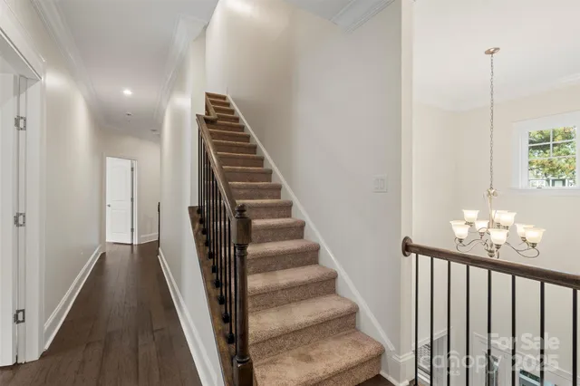 a view of staircase with railing and white walls