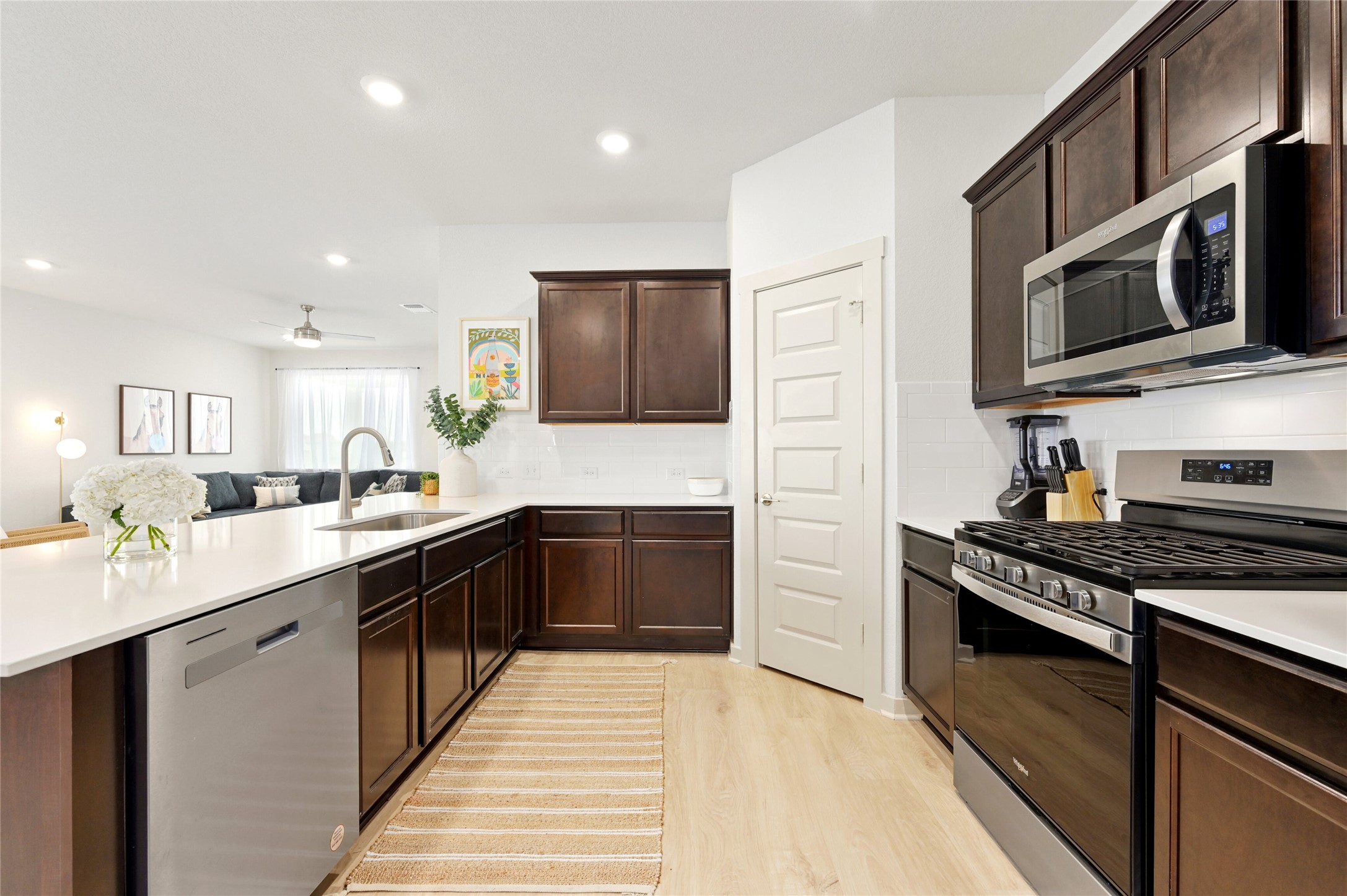 2300 Ranier Court Austin, TX 78754 - Photo 24 of 24 Kitchen featuring stainless steel appliances, dark wood finish cabinetry, a peninsula, light wood-style floors, and open floor plan