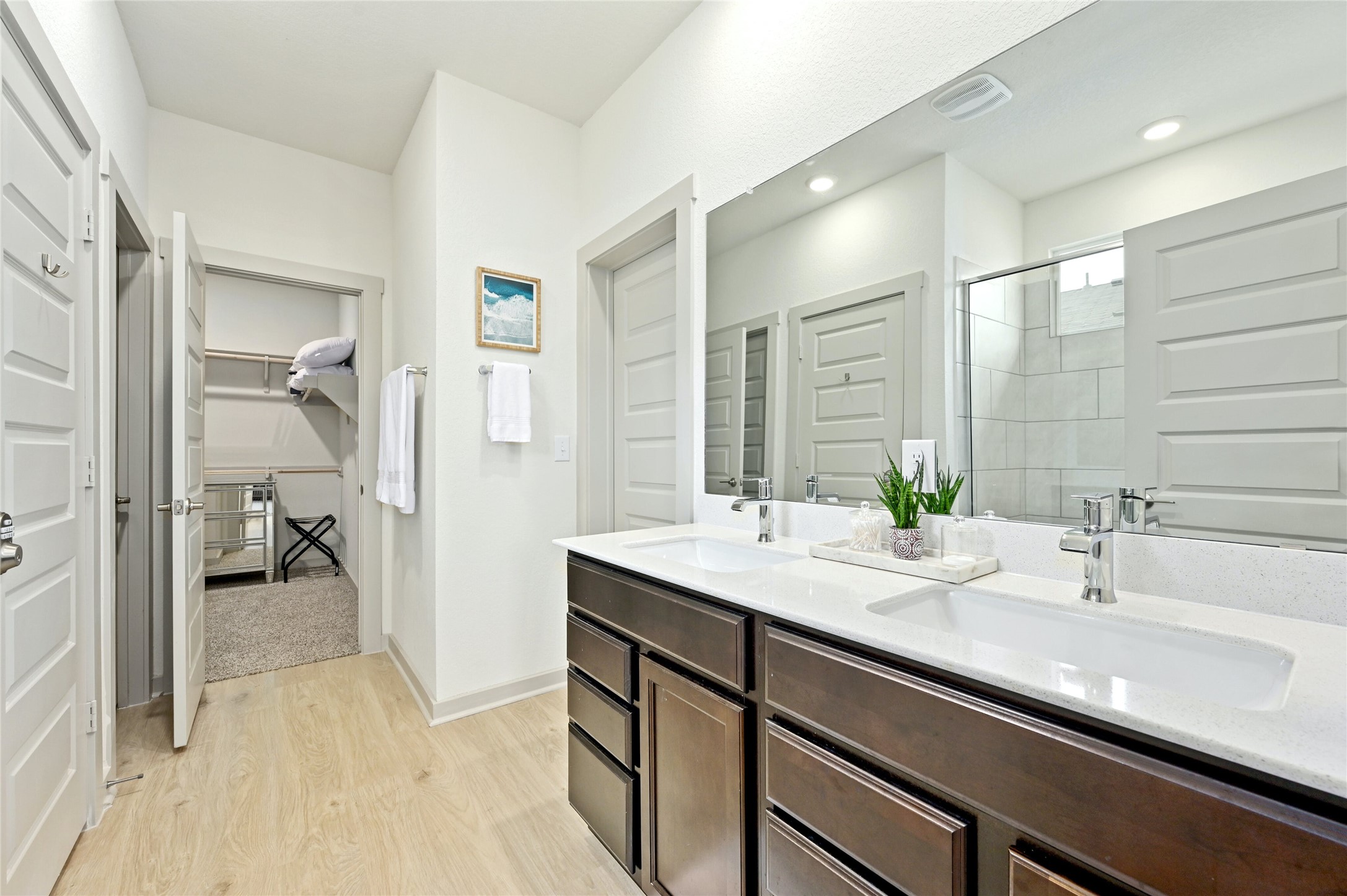 2300 Ranier Court Austin, TX 78754 - Photo 12 of 24 Full bathroom featuring a stall shower, double vanity, a spacious closet, and light wood finished floors