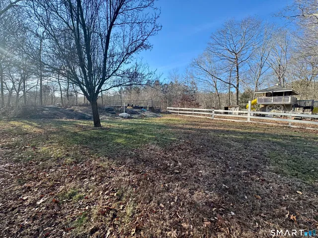 a view of a yard with wooden fence